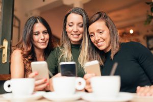 Photo de trois femmes qui regardent une vidéo sur leur smartphone